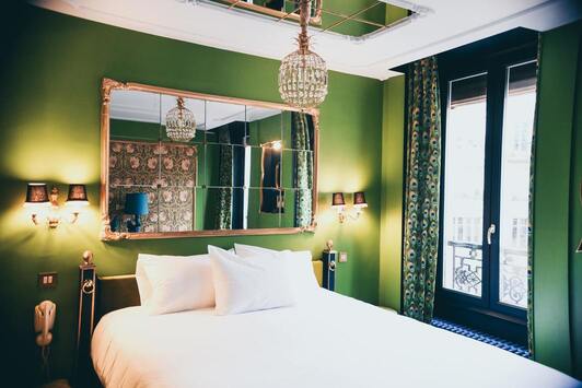 Chambre aux murs verts dans un style traditionnel, avec un lit double