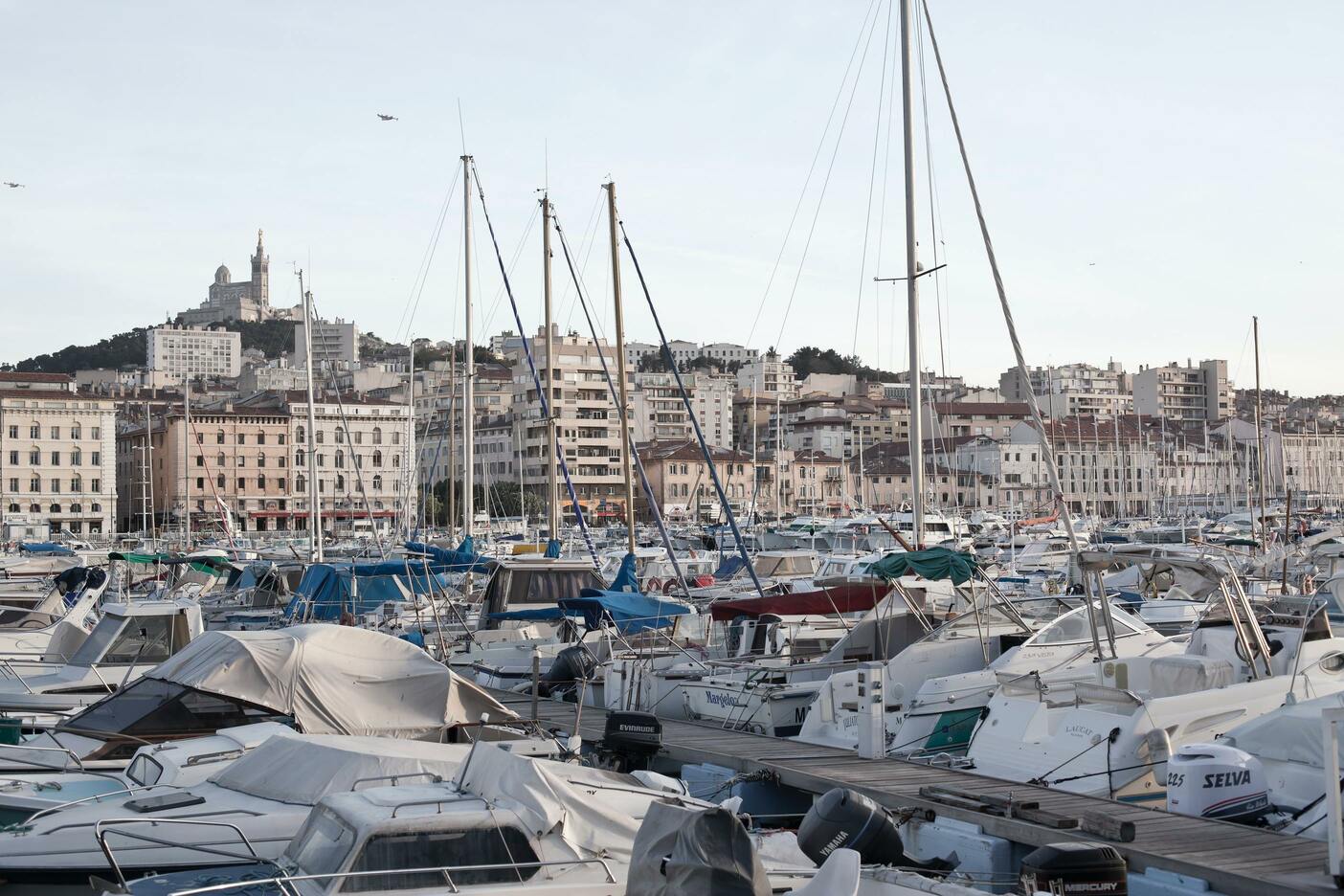 Des bateaux de plaisance et de pêche, et des bâtiments en fond. Cette image montre le Vieux-Port, à Marseille.